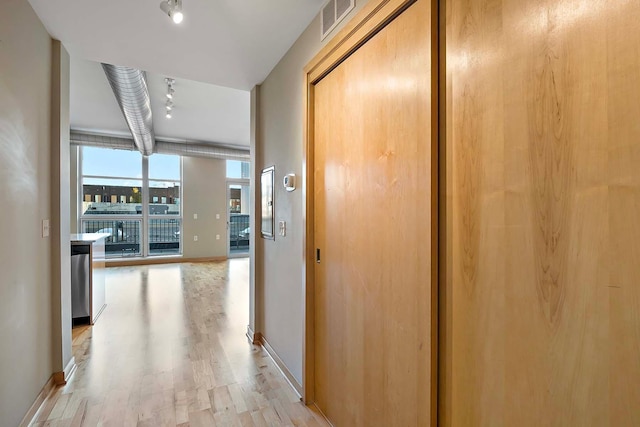 hall featuring a wall of windows and light hardwood / wood-style floors