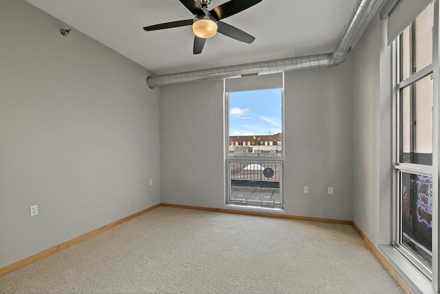 carpeted spare room with ceiling fan