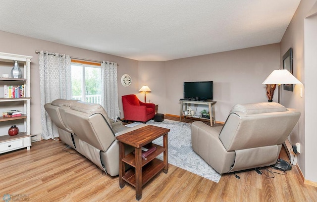 living room featuring light hardwood / wood-style floors and a textured ceiling