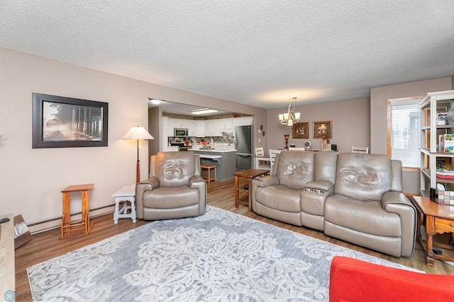 living room featuring a notable chandelier, a baseboard radiator, hardwood / wood-style floors, and a textured ceiling