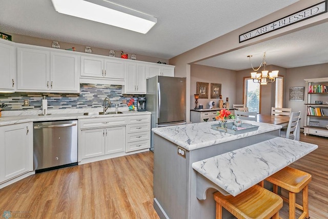 kitchen with white cabinets, an inviting chandelier, appliances with stainless steel finishes, and a center island