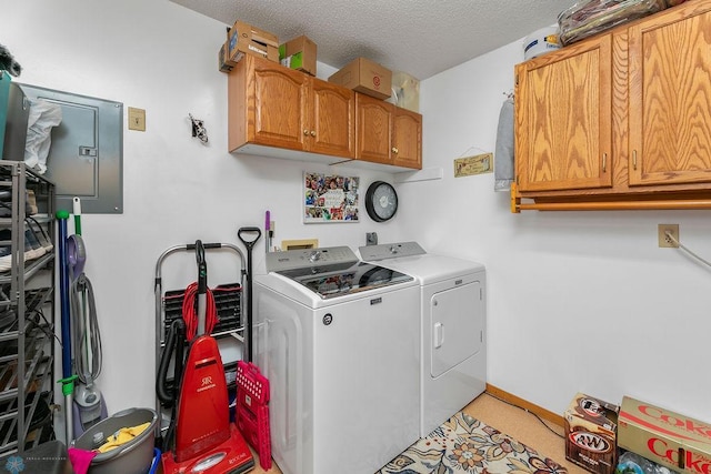 washroom with cabinets, a textured ceiling, and washing machine and dryer