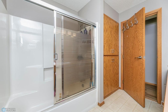 bathroom featuring enclosed tub / shower combo and a textured ceiling