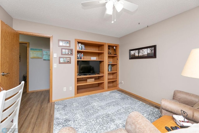 living room with a textured ceiling, light hardwood / wood-style floors, and ceiling fan