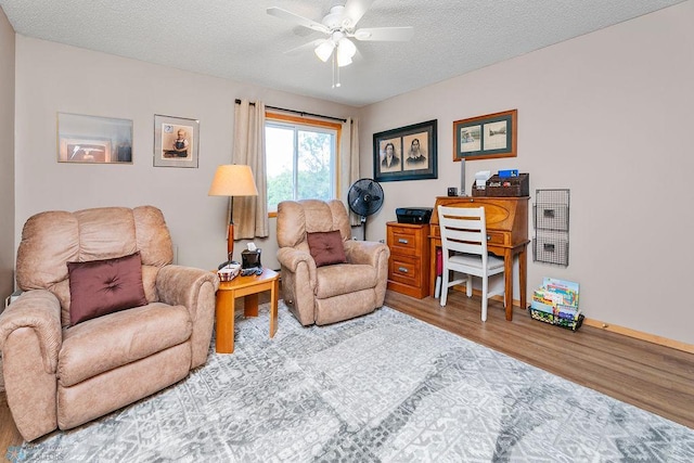 living room with a textured ceiling, light hardwood / wood-style floors, and ceiling fan