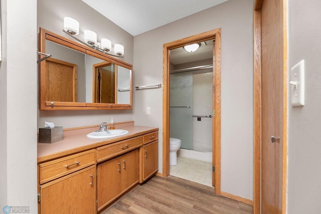 bathroom featuring vanity, hardwood / wood-style floors, toilet, and an enclosed shower