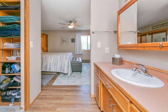 bathroom with ceiling fan, vanity, and hardwood / wood-style floors