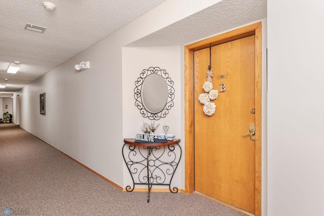 hall with a textured ceiling and carpet flooring