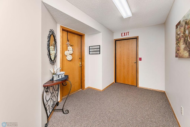 hallway with carpet floors and a textured ceiling