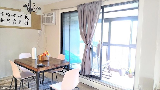 carpeted dining room featuring a baseboard radiator, a chandelier, plenty of natural light, and a wall mounted AC