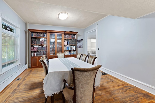 dining room with ornamental molding, a textured ceiling, and dark hardwood / wood-style flooring