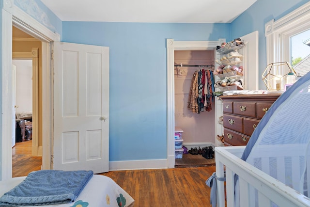 bedroom with dark hardwood / wood-style flooring and a closet