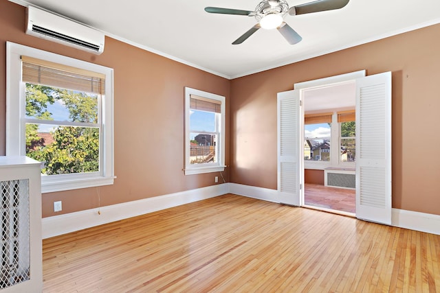 empty room with a wealth of natural light, light hardwood / wood-style floors, and ceiling fan