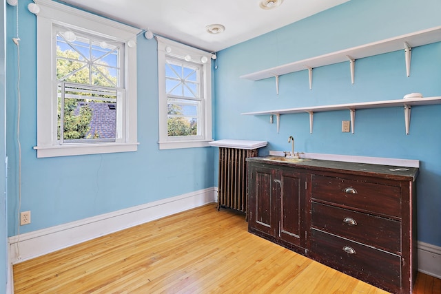 bedroom with light wood-type flooring and sink