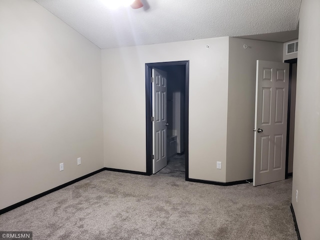 unfurnished room featuring light carpet and a textured ceiling