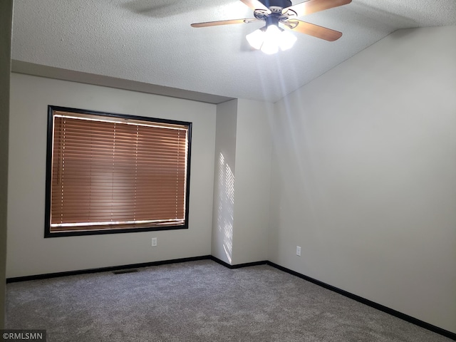 spare room with carpet, lofted ceiling, ceiling fan, and a textured ceiling