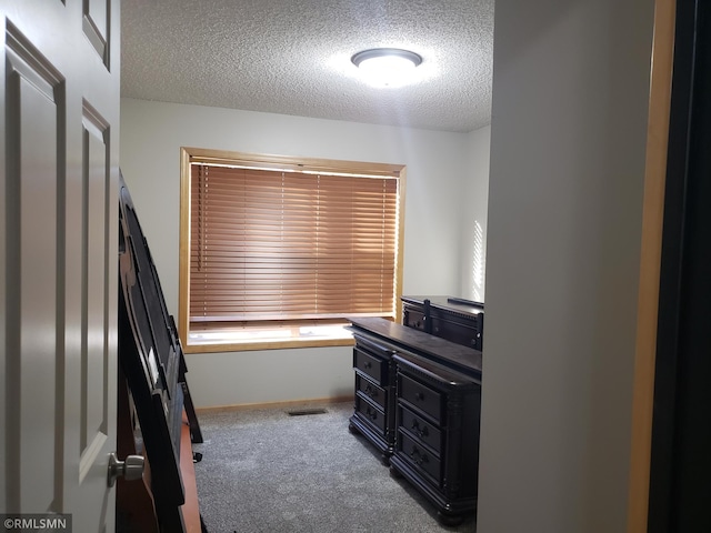 carpeted bedroom featuring a textured ceiling