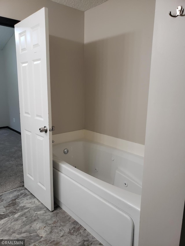 bathroom featuring a textured ceiling and a washtub