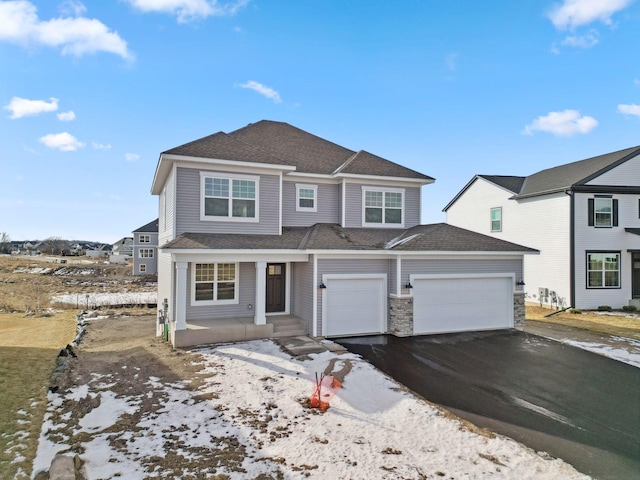 view of front of home featuring aphalt driveway, a garage, and roof with shingles