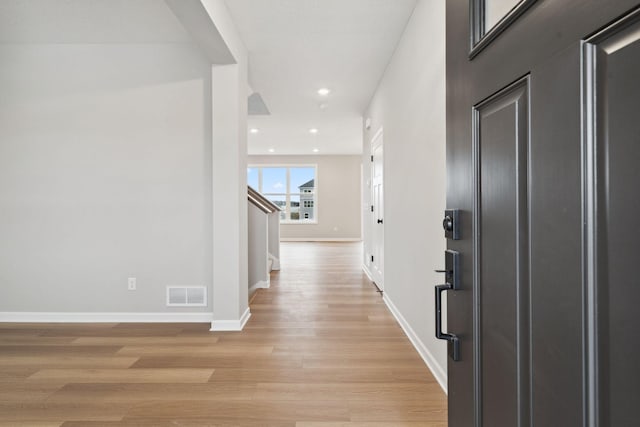 foyer entrance with visible vents, recessed lighting, light wood-style floors, baseboards, and stairs