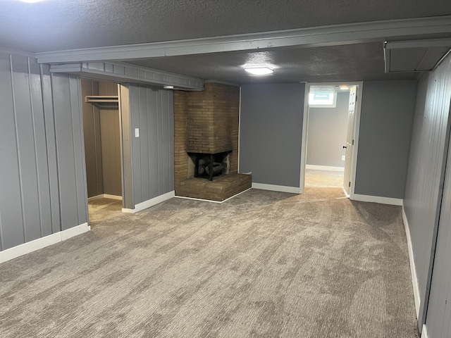 basement with light carpet, a fireplace, wood walls, and a textured ceiling