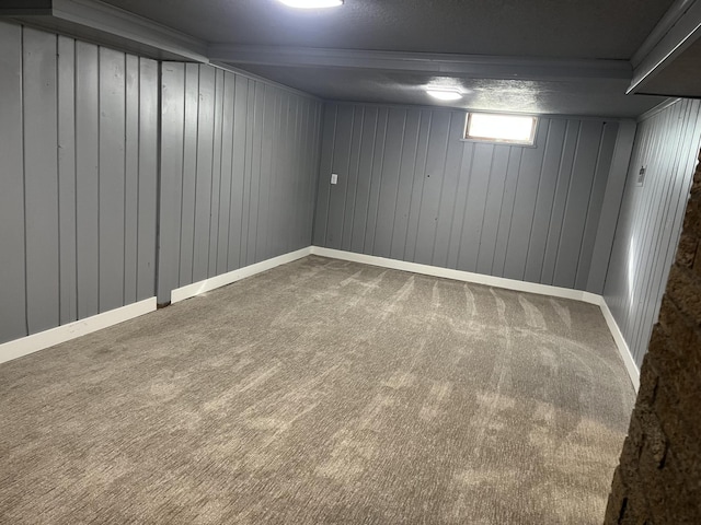 basement with ornamental molding and carpet