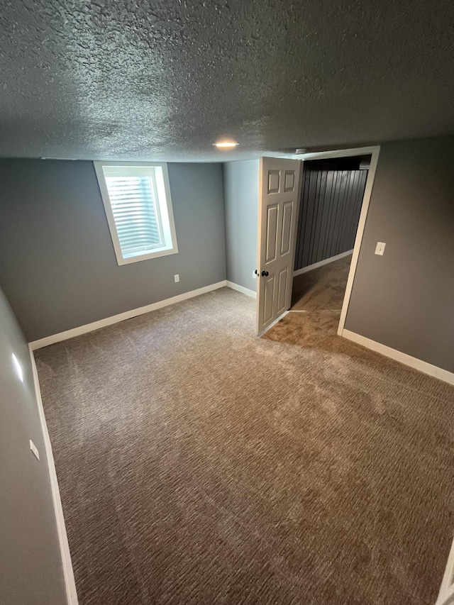 basement featuring a textured ceiling and carpet flooring