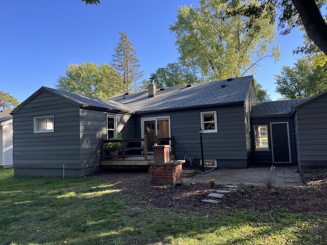 back of house with a lawn, a deck, and a patio