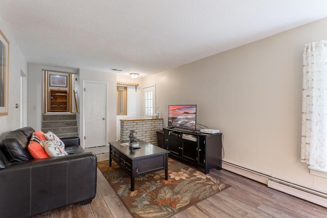 living room featuring a textured ceiling, a baseboard radiator, and dark hardwood / wood-style flooring