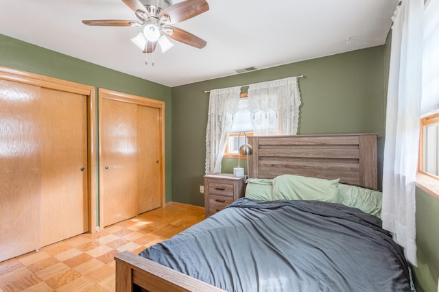 bedroom featuring multiple closets and ceiling fan