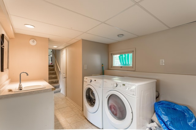 washroom featuring light tile patterned floors, sink, and washing machine and clothes dryer