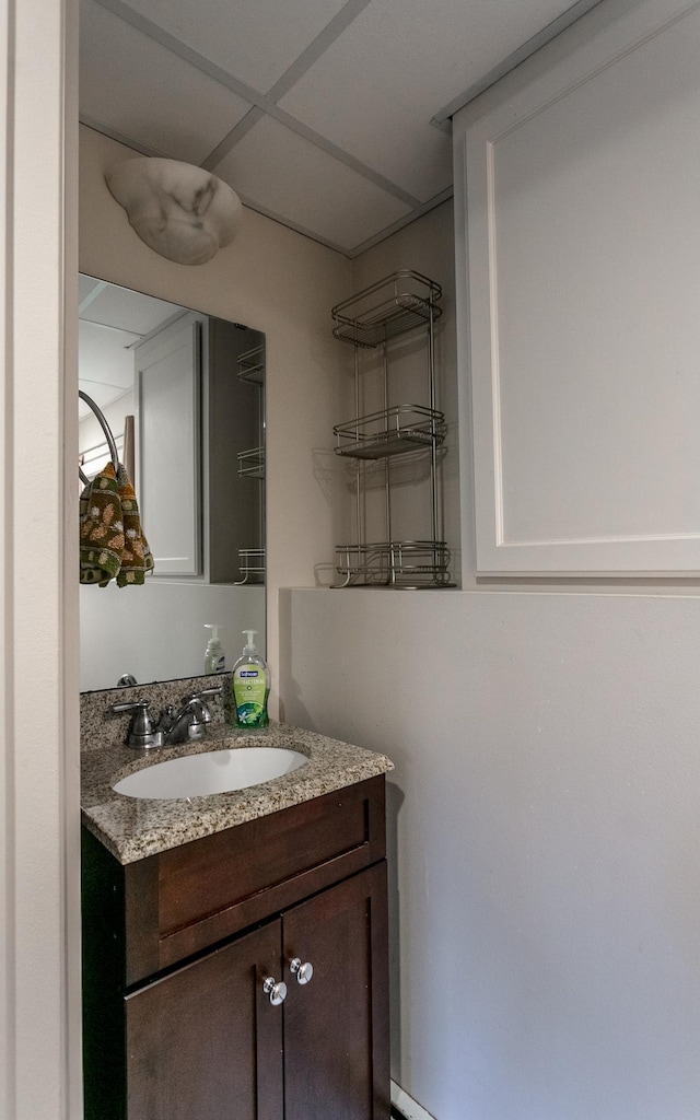 bathroom with a paneled ceiling and vanity