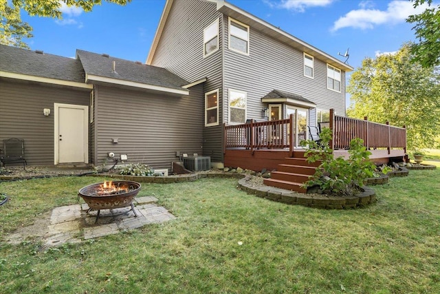 back of property featuring a deck, a yard, and an outdoor fire pit