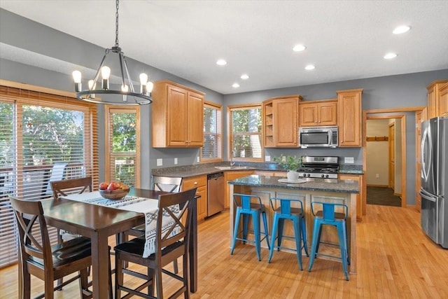 kitchen with a notable chandelier, a center island, stainless steel appliances, and a wealth of natural light