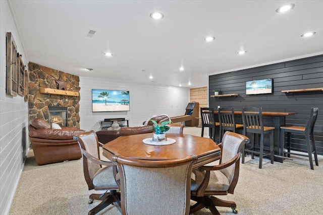 carpeted dining room with a fireplace