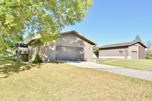 view of property exterior with a detached garage and a yard