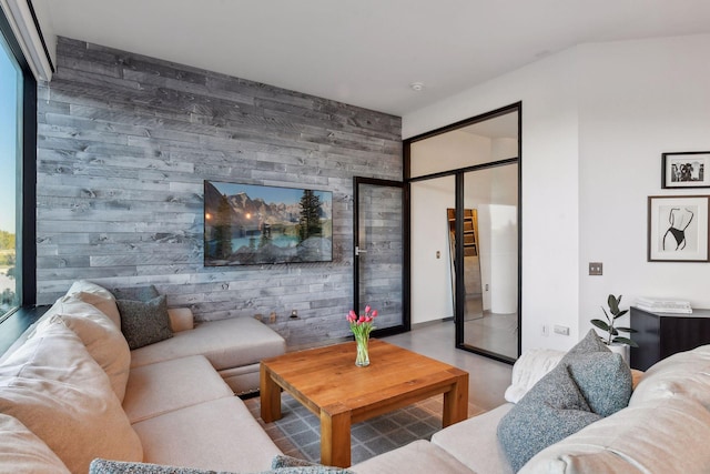 living room with concrete flooring and wood walls