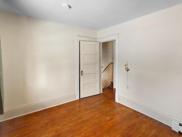 spare room with a baseboard radiator and hardwood / wood-style floors