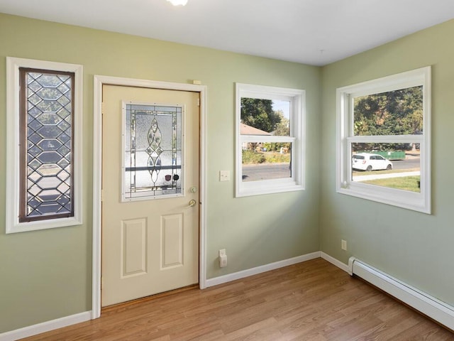 doorway to outside featuring a baseboard radiator and light hardwood / wood-style flooring