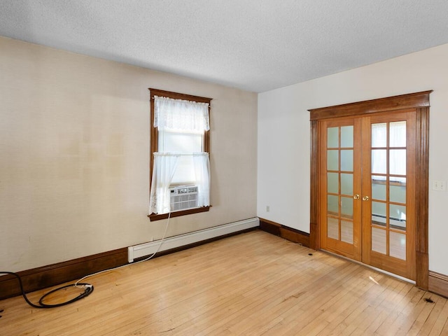 unfurnished room featuring light wood-type flooring, a textured ceiling, french doors, and a baseboard radiator