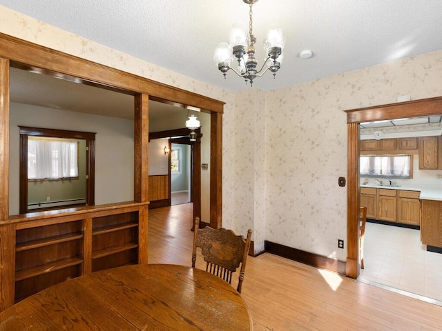 unfurnished dining area featuring sink, a chandelier, and light hardwood / wood-style floors