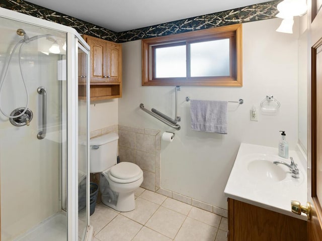 bathroom featuring a shower with shower door, vanity, tile patterned flooring, and toilet