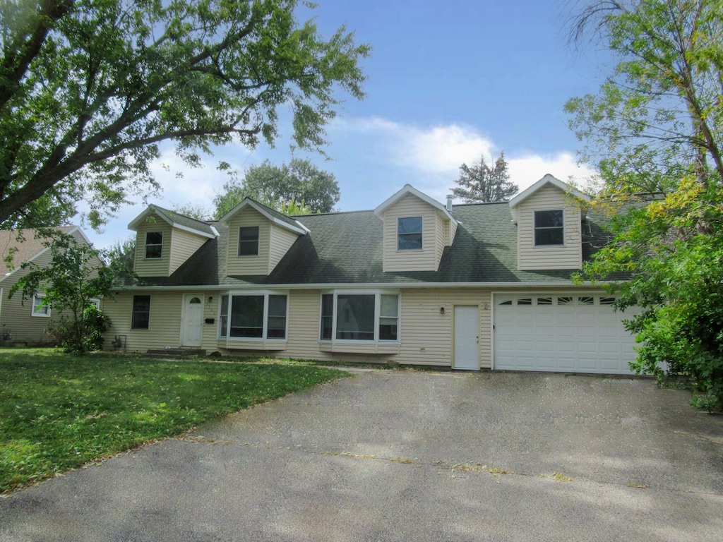 cape cod house featuring a front lawn