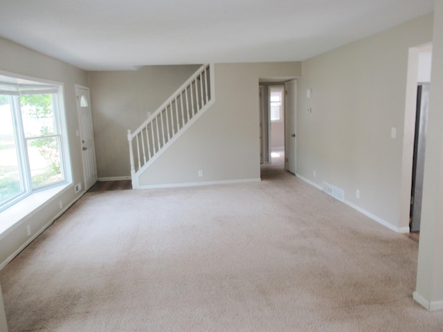 unfurnished room featuring light carpet