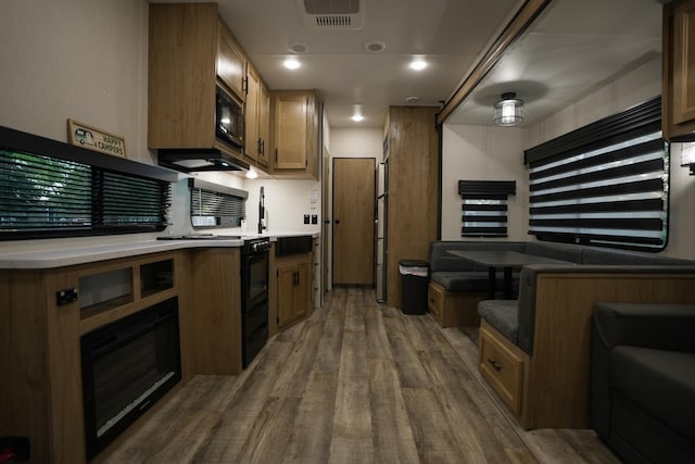 kitchen featuring black microwave and dark hardwood / wood-style flooring