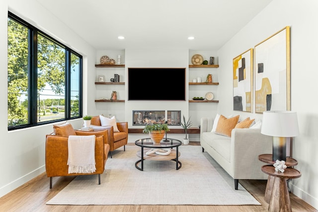 living room featuring built in features and light wood-type flooring