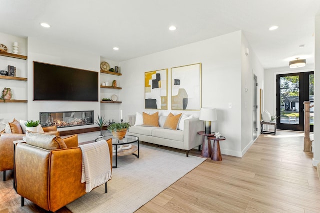 living room featuring built in shelves and light wood-type flooring