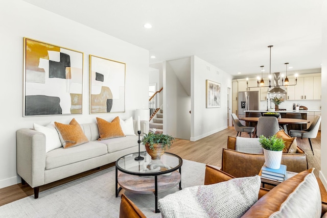 living room with a notable chandelier and light wood-type flooring