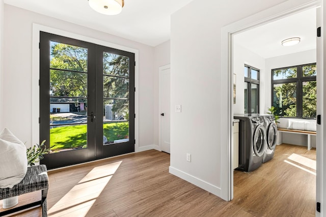 doorway to outside featuring a wealth of natural light, light hardwood / wood-style floors, washer and dryer, and french doors