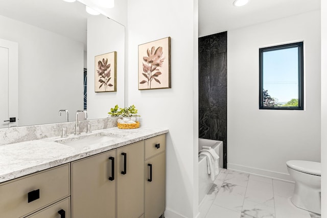 bathroom featuring vanity, a washtub, and toilet